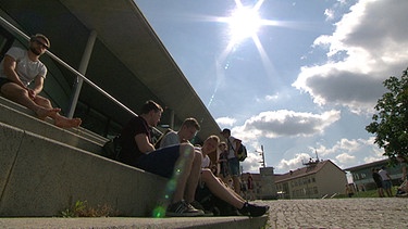 Studenten sitzen vor der Uni | Bild: BR