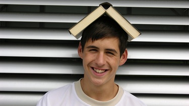 Junge mit Buch auf dem Kopf | Bild: picture-alliance/dpa