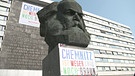 Denkmal Karl-Marx-Monument. Wahrzeichen der Stadt mit Plakat | Bild: BR