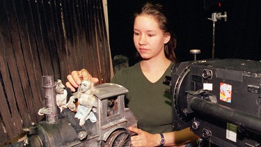 Tine Kluth, Studentin der Ludwigsburger Filmakademie, zeigt vor einer Trickfilmkamera Figuren auf einer Lokomotive, die in ihrem Animationsfilm in Szene gesetzt werden | Bild: picture-alliance/dpa