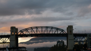 Wolkenspiel über Vancouver: Der Blick von Granville Island aus auf die Brücke der Burrard Street im Sonnenuntergang. | Bild: Jens Lange