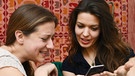 zwei Freundinnen schauen auf ein smartphone | Bild: picture-alliance/dpa