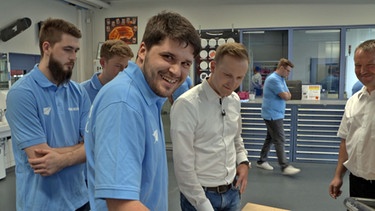 Max Wottrich (hinten) in der Ausbildungsabteilung bei Premium Aerotec mit Dualstudenten, sie zeigen ihm gerade einen Radanhänger, den sie aus Fiberglas gefertigt haben | Bild: BR