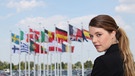 Junge Frau steht vor Flaggen, die zur EU gehören. | Bild: colourbox.com
