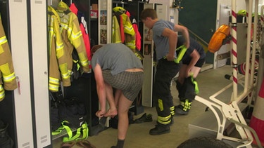 Bei einem Einsatz heißt es schnell in die Feuerwehrkleidung schlüpfen und ausrücken. | Bild: BR