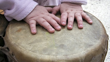Kinderhand auf Trommeln | Bild: picture-alliance/dpa