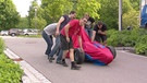 Studierende schieben ihren verhüllten Rennwagen | Bild: BR