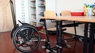 leerer Rollstuhl am Tisch mit Stühlen - Gelingt Inklusion in der Gesellschaft? | Bild: picture-alliance/dpa