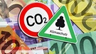 Klimaschutz-Schild und CO2-Verbotsschild vor Geldscheinen, Symbolfoto CO2-Steuer | Bild: picture alliance | Christian Ohde