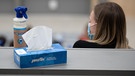 Eine Box mit Papiertüchern und eine Sprühflasche mit Desinfektionsmittel steht neben einer Studentin in der Begrüßungsveranstaltung für Studierende im ersten Semester. | Bild: picture alliance/dpa | Sebastian Gollnow