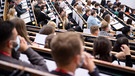 Studentinnen und Studenten sitzen im großen Hörsaal der Universität Bremen.  | Bild: picture alliance/dpa | Sina Schuldt