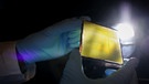 Ein Forscher hält ein Element einer Photoelektrochemischen Zelle (PEC), ein sogenanntes „Künstliches Blatt“ in einem Labor im Helmholtz-Zentrum hereon in Geesthacht.  | Bild: picture alliance/dpa | Christian Charisius