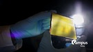 Ein Forscher hält ein Element einer Photoelektrochemischen Zelle (PEC), ein sogenanntes „Künstliches Blatt“ in einem Labor im Helmholtz-Zentrum hereon in Geesthacht mit Campus Talks Logo | Bild: picture alliance/dpa | Christian Charisius