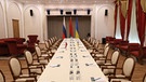 The table for peace talks between Russian and Ukrainian delegations in a guest house in Gomel region, Belarus is seen Monday, Feb. 28, 2022. The Russian and Ukrainian delegations met for their preliminary talks Monday. The meeting is taking place in Gomel region on the banks of the Pripyat River. | Bild: picture alliance / ASSOCIATED PRESS | Sergei Kholodilin