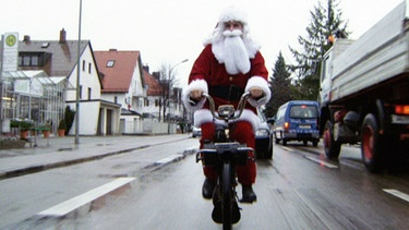 Salim fährt als Weihnachtsmann verkleidet Fahrrad | Bild: BR/Tellux-Film GmbH
