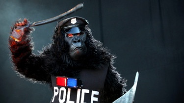 Ein Musiker einer Punkband ist als Gorilla in Polizeiuniform verkleidet | Bild: picture-alliance/dpa