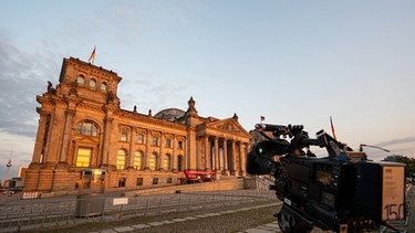 26.09.2021, Berlin: Eine Fernsehkamera steht vor dem Reichstagsgebäude, dem Sitz des Bundestag, in der Abendsonne, nachdem die Wahllokale bei der Bundestagswahl geschlossen haben. Foto: Monika Skolimowska/dpa-Zentralbild/dpa +++ dpa-Bildfunk +++ | Bild: dpa-Bildfunk/Monika Skolimowska