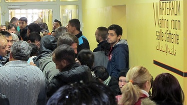 Warteschlange in einer Aufnahmeeinrichtung für Asylbegehrende  | Bild: picture-alliance/dpa