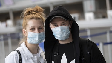 Menschen mit Gesichtmasken am Flughafen | Bild: dpa-Bildfunk / Boris Roessler