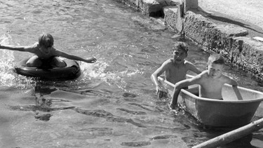 Kinder spielen im Jahr 1961 in einem Bach im mittelfränkischen Pleinfeld | Bild: picture-alliance/dpa