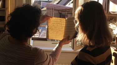 Zwei Menschen schauen sich alte Musiknoten an, Volksmusik aus Franken | Bild: FFV / Forschungsstelle für Fränkische Volksmusik