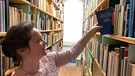 Eine Frau holt ein Buch aus der Bibliothek, Volksmusik aus Franken | Bild: FFV / Forschungsstelle für Fränkische Volksmusik