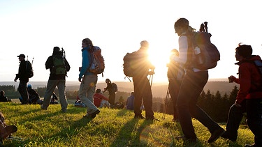 Tief stehende Sonne hinter einer Gruppe von Wanderern | Bild: Frankenwald Tourismus / Andreas Hub