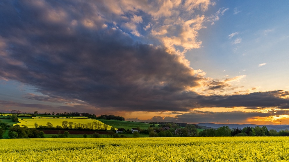 Kurz vor Sonnenuntergang bildete sich ein dramatischer Abendhimmel über leuchtend gelbe Rapsfelder. Aufgenommen bei Troschenreuth (Oberfranken) mit Fernblick in die fränkische Schweiz. | Bild: Karl-Heinz Schmid, Auerbach, 15.05.2023