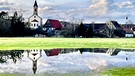 Die St. Andreas Kirche in Wasermungenau spiegelt sich in einer großen Wasserlache im Retzatgrund. | Bild: Kerstin Mahr, Wassermungenau, 14.02.2024