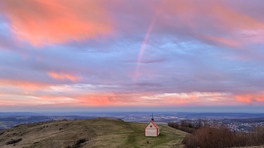 Die Walburgis-Kapelle auf dem Walberla zum Sonnenaufgang mit Regenbogen. | Bild: Stefan Hagel, Forchheim, 16.02.2024
