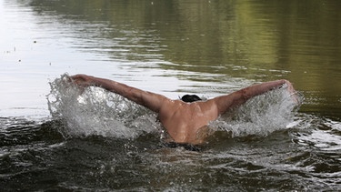 Ein Mann schwimmt in der Regnitz bei Bamberg | Bild: picture-alliance/dpa