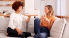 Zwei Frauen sitzen auf dem Sofa und unterhalten sich miteinander. | Bild: colourbox.com
