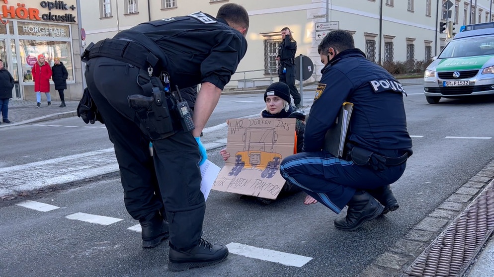 Klimaaktivisten der "Letzten Generation" haben sich in Anlehnung an die Bauerndemos mit Mini-Traktoren auf eine Straße in Passau geklebt. | Bild: Bayerischer Rundfunk 2024