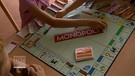 Kinderarm über einem Monopoly-Spiel | Bild: Bayerischer Rundfunk 2024