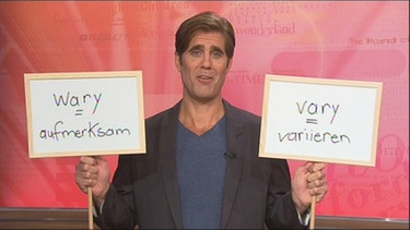 Eric mit zwei Schildern: wary (aufmerksam) und vary (variieren) | Bild: Bayerischer Rundfunk