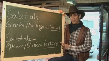 Der Cowboy mit einer Tafel und den unterschiedlichen Bedeutungen von Salat | Bild: Bayerischer Rundfunk