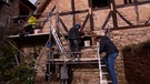 Mehrere Menschen arbeiten an der Fassade eines alten Hauses | Bild: Bayerischer Rundfunk 2023
