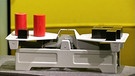 Eine Waage im Gleichgewicht mit unterschiedlichen Objekten; links Quader und Zylinder, rechts nur Quader | Bild: BR