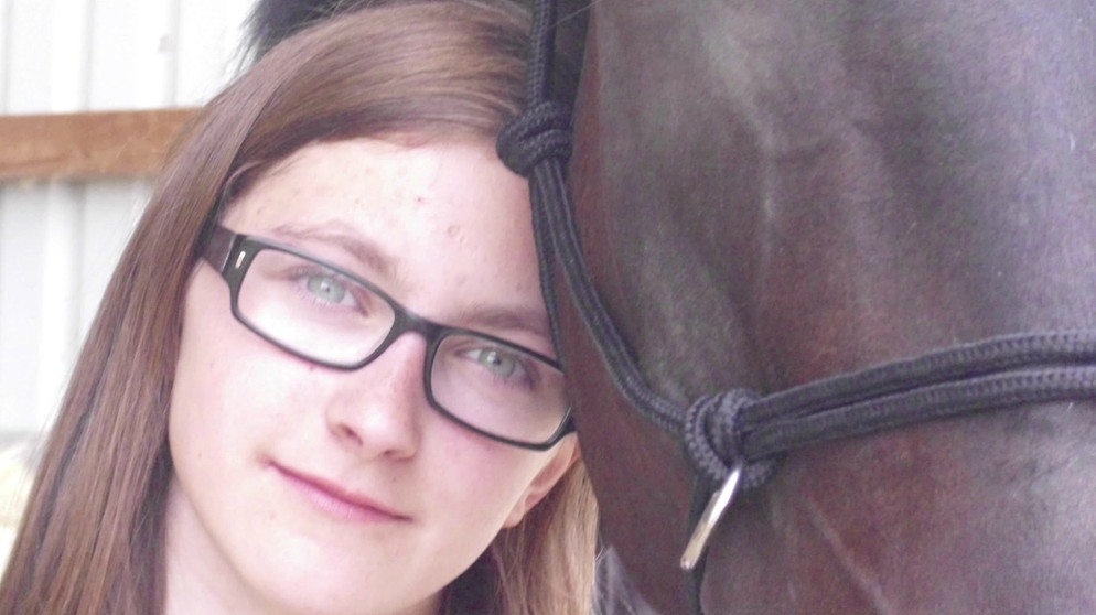 Lea, an einen Pferdekopf gelehnt | Bild: Bayerischer Rundfunk