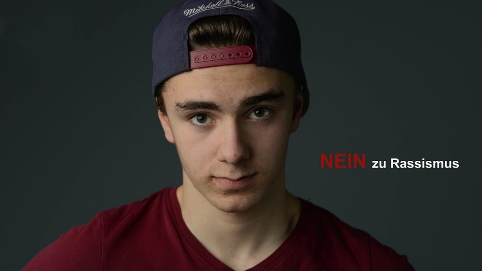 Moritz mit Cap, neben ihm der Slogan "Nein zu Rassismus" | Bild: Bayerischer Rundfunk