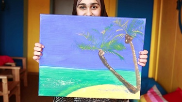 Rahgad mit einem ihrer Kunstwerke - ein Strand mit Palmen | Bild: Bayerischer Rundfunk