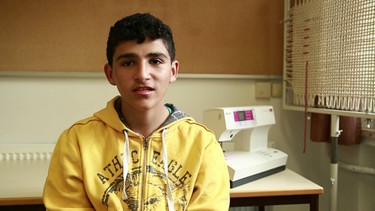 Asad sitzt vor einer Nähmaschine | Bild: Bayerischer Rundfunk