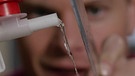 Wasserstrahl wird durch elektrostatisch aufgeladenes Plexiglas verbogen | Bild: Bayerischer Rundfunk