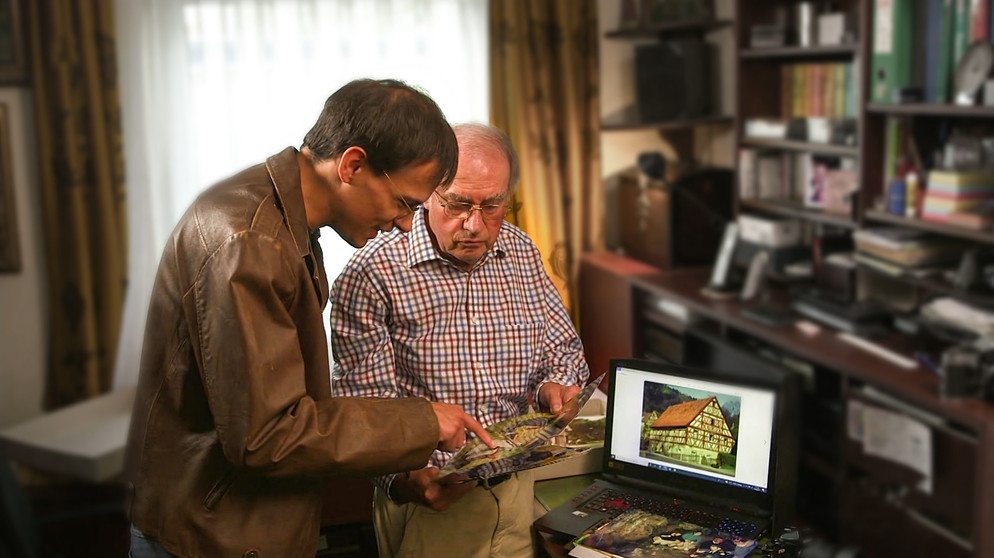 Adrian und Mann schauen Fotos an | Bild: BR Fernsehen