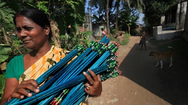 Eine Frau trägt ein Bündel Feuerwerkskörper in Kalkutta | Bild: picture-alliance/dpa