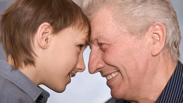 Ein Großvater und sein Enkel lachen miteinander. | Bild: colourbox.com