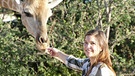 Anna macht sich in Namibia auf die Suche nach den großen Paarhufern. Eine handzahme Giraffe kann sie sogar streicheln. | Bild: BR/TEXT + BILD Medienproduktion GmbH & Co. KG/