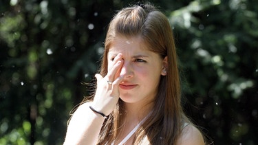 Ein Mädchen reibt sich ein Auge. | Bild: picture-alliance/dpa