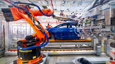 Roboter montieren Bauteile eines E-Autos. | Bild: dpa-Bildfunk/Sina Schuldt