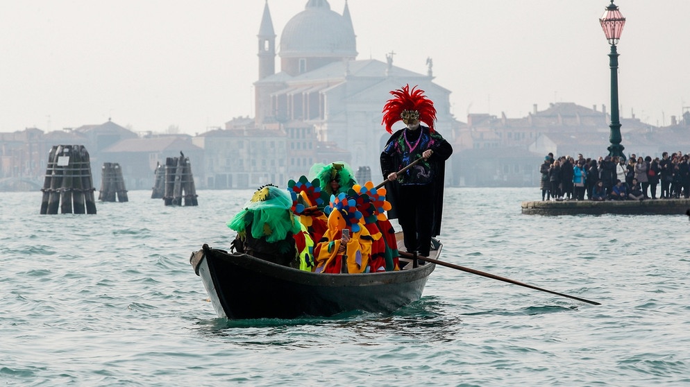 verkleidete Personen fahren mit einer Gondel über das Wasser. | Bild: dpa-Bildfunk